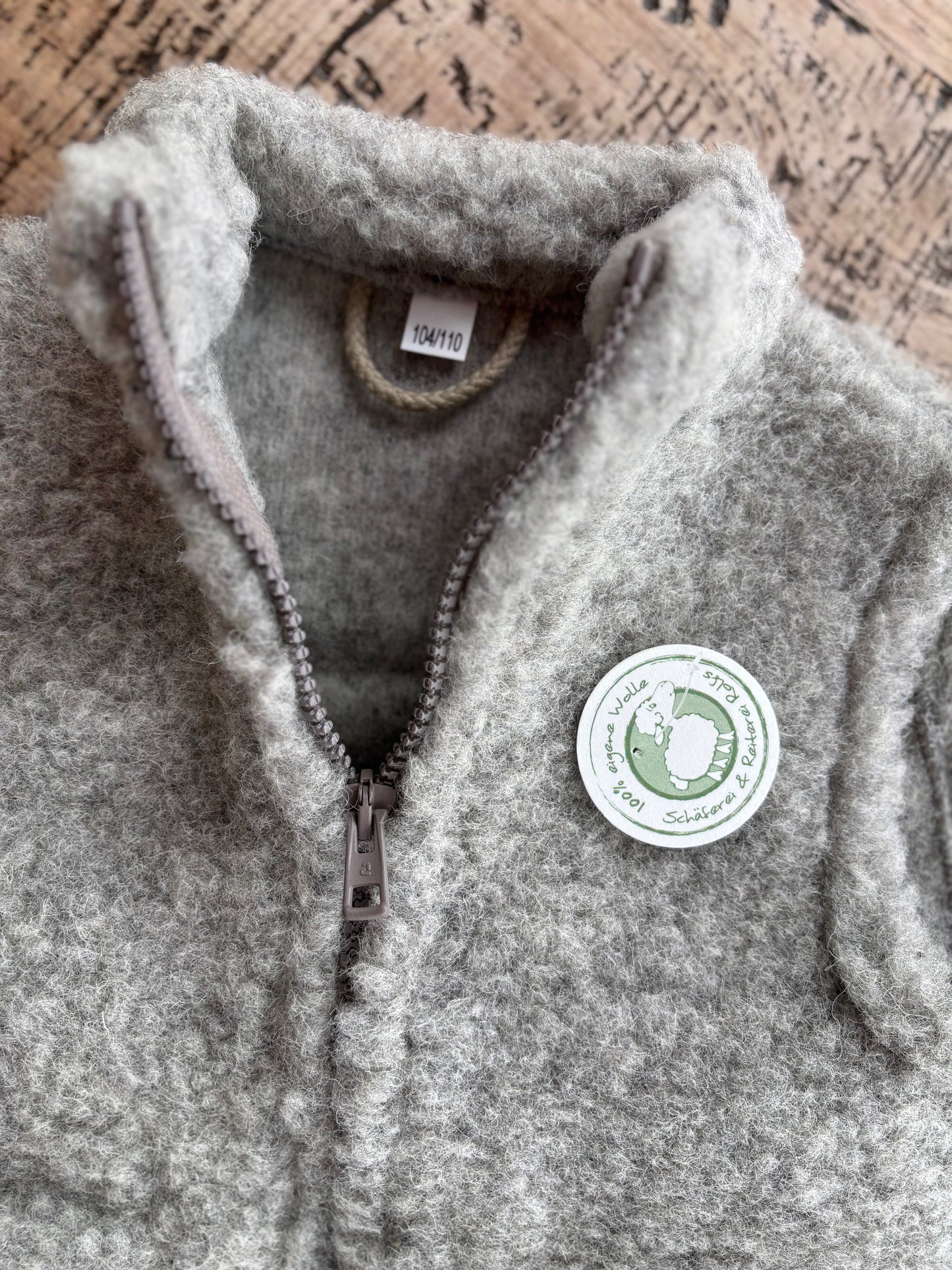 Detailaufnahme der grauen Kinderweste aus Schurwolle – fein verarbeitete Nähte und natürliche Wollstruktur, hergestellt in Deutschland bei der Schäferei Rolfs an der Nordsee. Nachhaltig, warm und robust – ideal für aktive Kinder.


